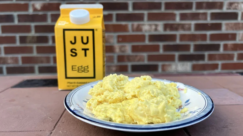 A carton of JUST Egg and a dish of cooked eggs