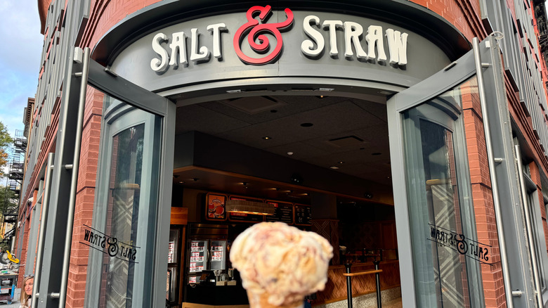 person holding ice cream in front of Salt & Straw location