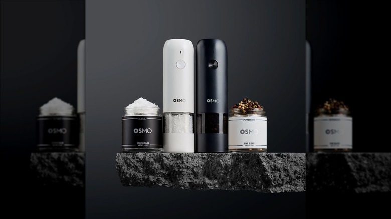 Osmo salt and pepper grinders next to jars of Osmo salt and peppercorns