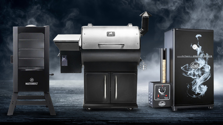 Three electric smokers side by side on a dark background