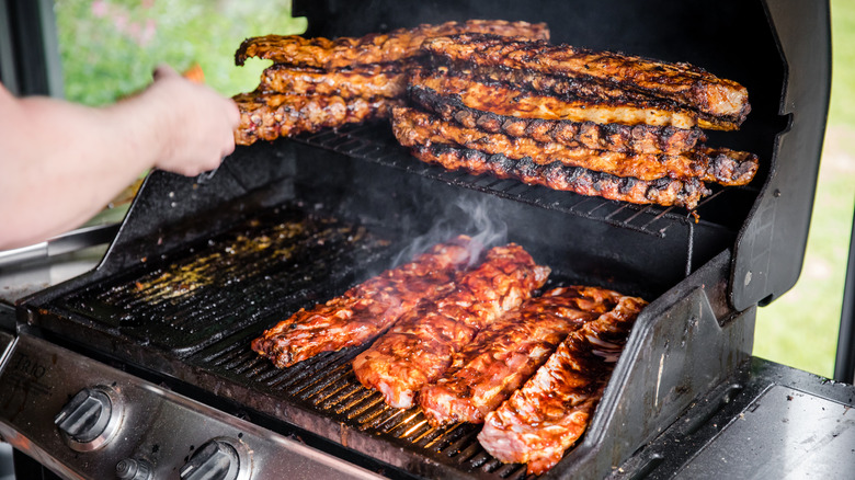 A person cooking meat on a grill