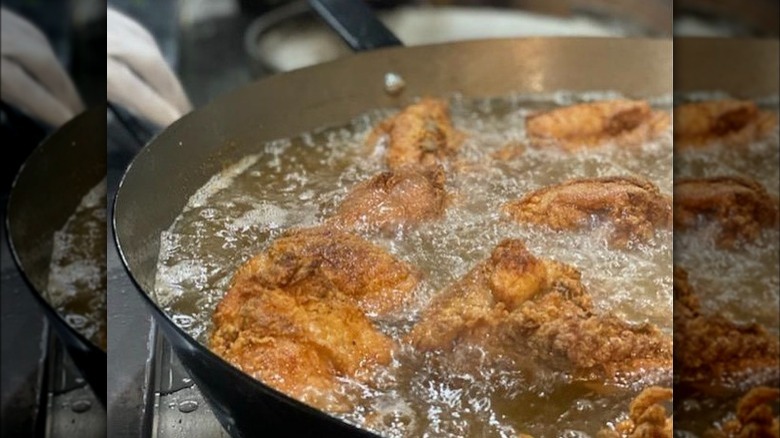 skillet with frying chicken