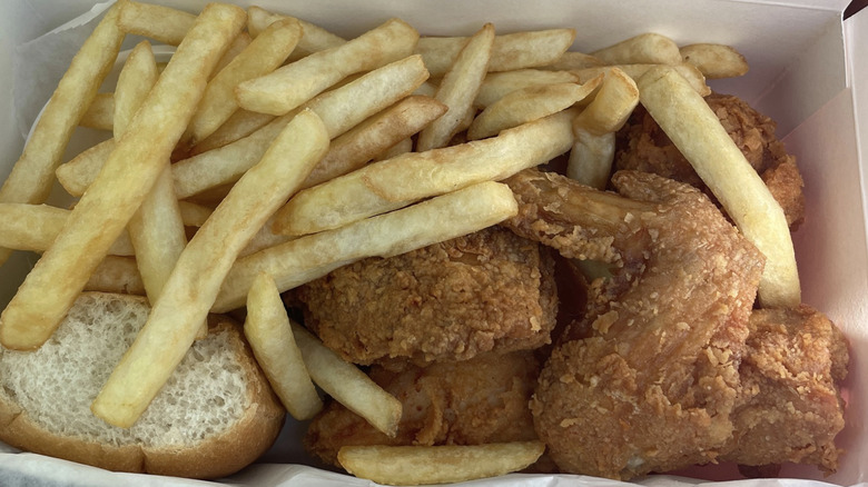 basket with fried chicken wings and fries