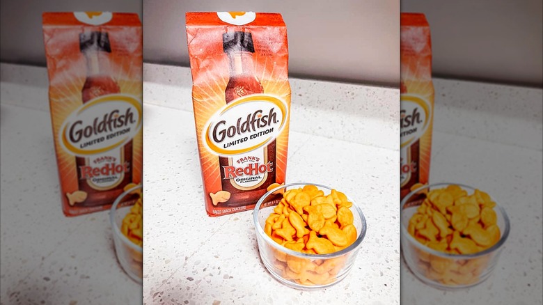 Frank's RedHot Goldfish crackers in a bowl next to brand packaging on a counter
