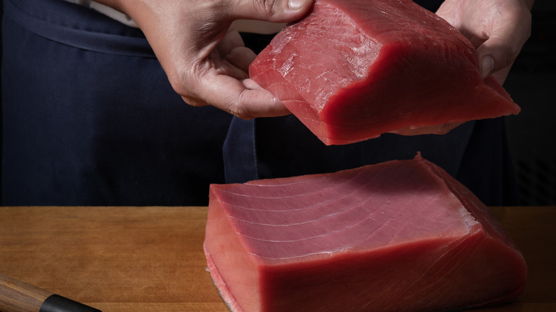 hand holding raw tuna steak