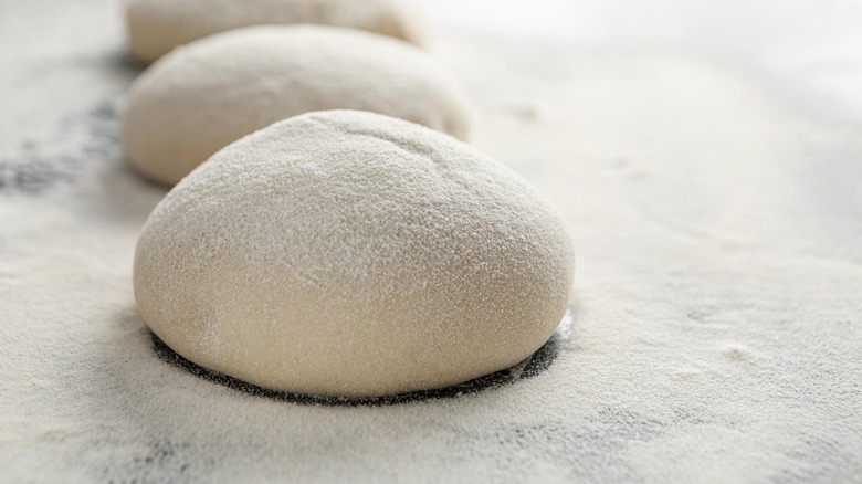 Pizza dough on floured surface