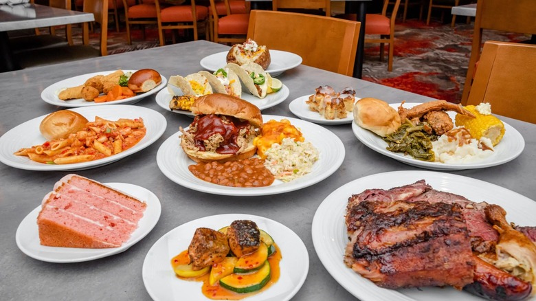 White plates of buffet items on grey table at The Kitchens at Southland Casino Hotel