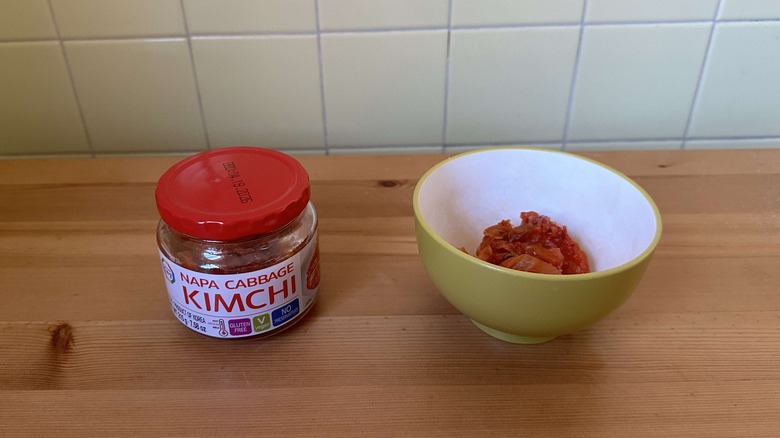 Jar of Surasang Napa cabbage kimchi next to bowl of kimchi