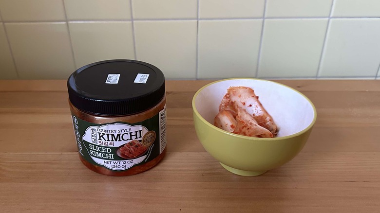 Tobagi country style sliced kimchi container next to bowl of kimchi