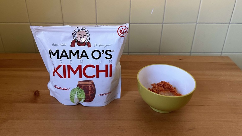 Bag of Mama O's premium kimchi next to bowl of kimchi