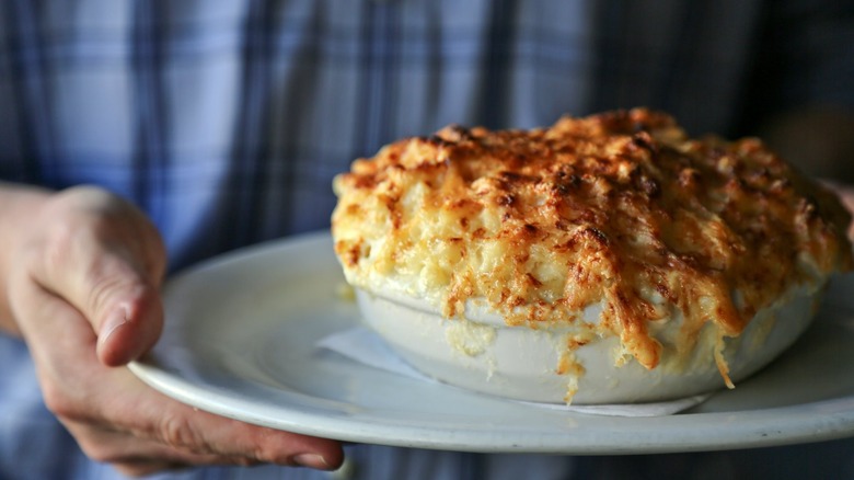 person holding macaroni au gratin 