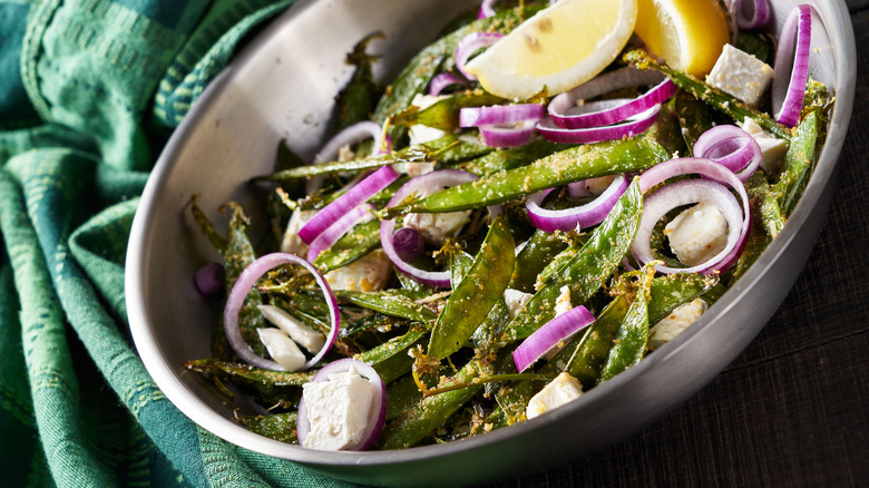 sugar snap peas in skillet with lemon and onion