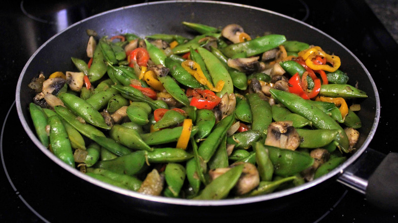 Snap peas cooking in skillet stir fry