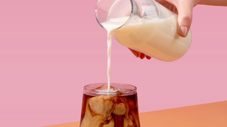 pouring creamer into iced coffee