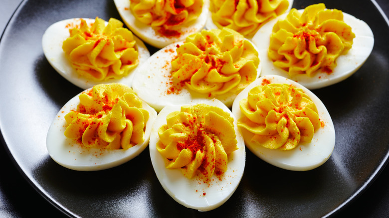 Deviled eggs with paprika sprinkled over on plate