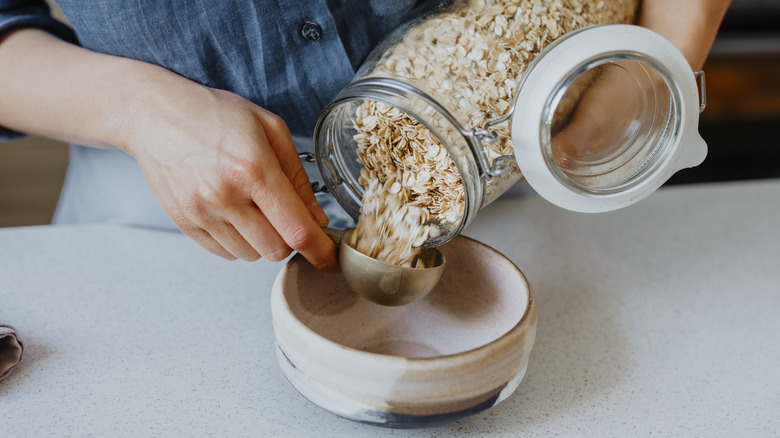 woman pouring rolled oats