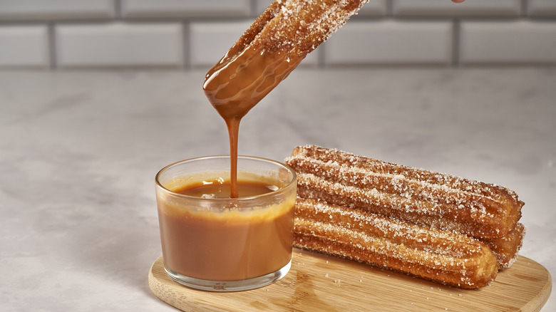 Churro dipped in caramel on counter