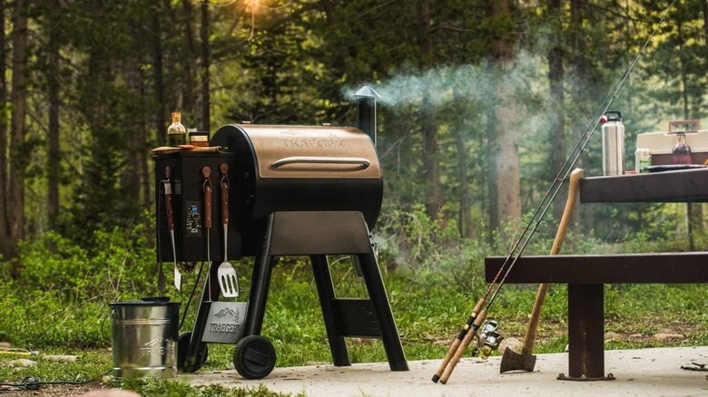 Traeger Grills Pro 22 sitting outside in forest clearing next to picnic bench