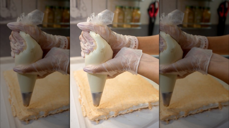 Piping frosting onto cake layer
