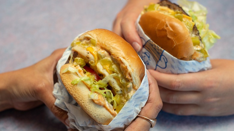 Fosters Freeze hands holding two burgers