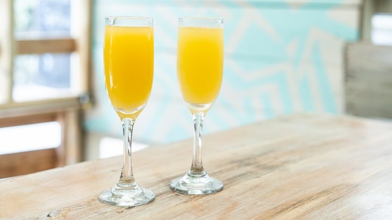 two glasses of mimosas at a bar 