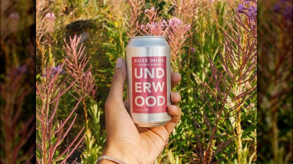 Hand holding a can of Underwood Rose Wine outside