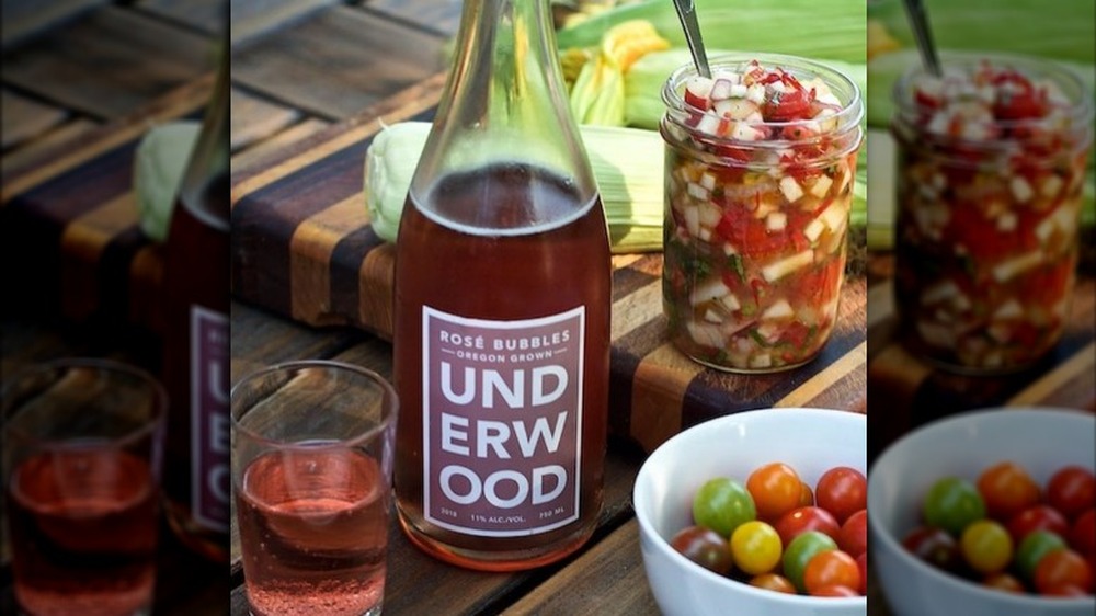 Open bottle of Underwood rose bubbles on a table with fresh tomatoes