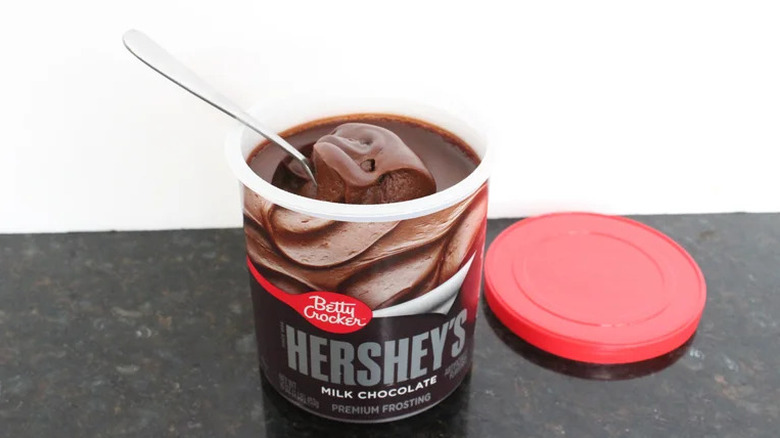 Betty Crocker Hershey's Milk Chocolate frosting with a spoon scooping up a dollop