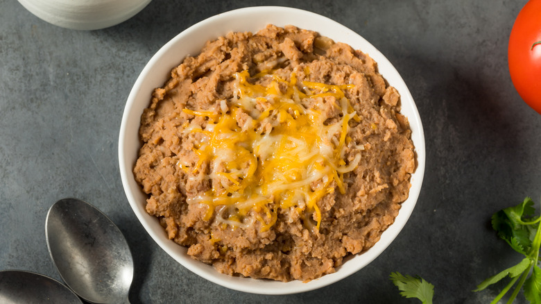 Bowl of refried beans topped with cheese 