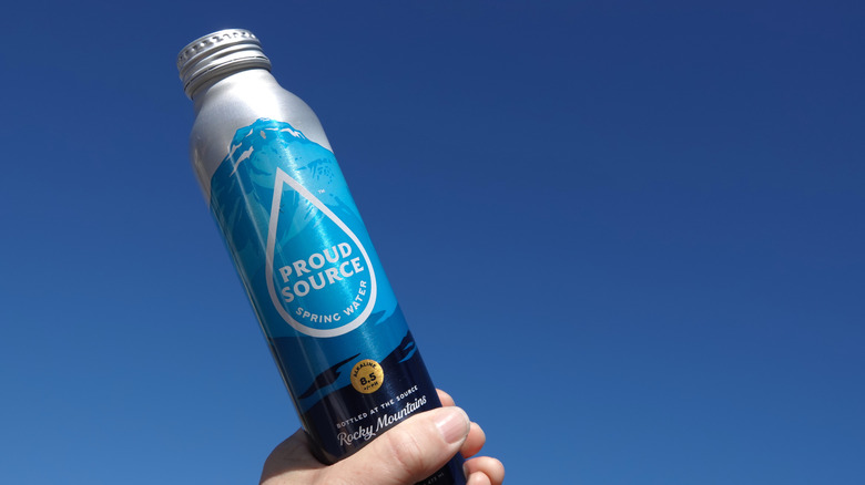 Someone holding a bottle of Proud Source water