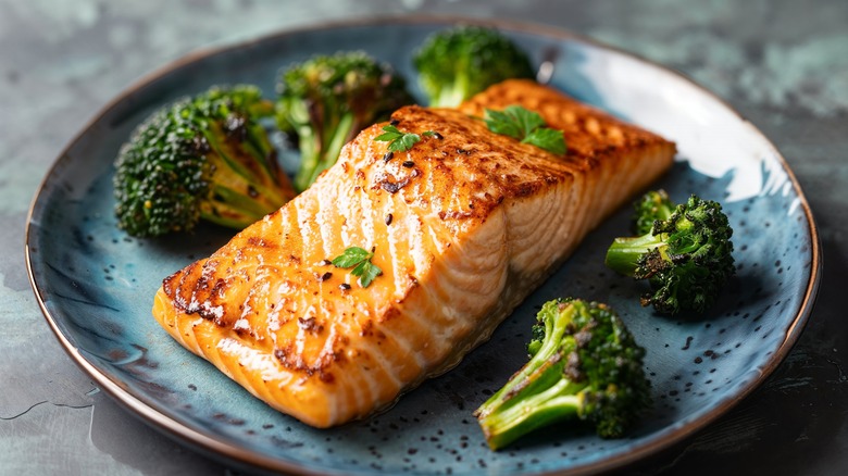 Salmon and broccoli on blue plate