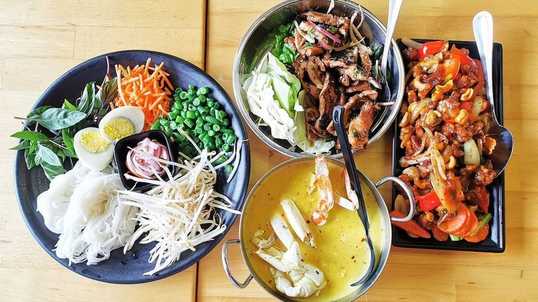 Four Southern Thai dishes on wooden table