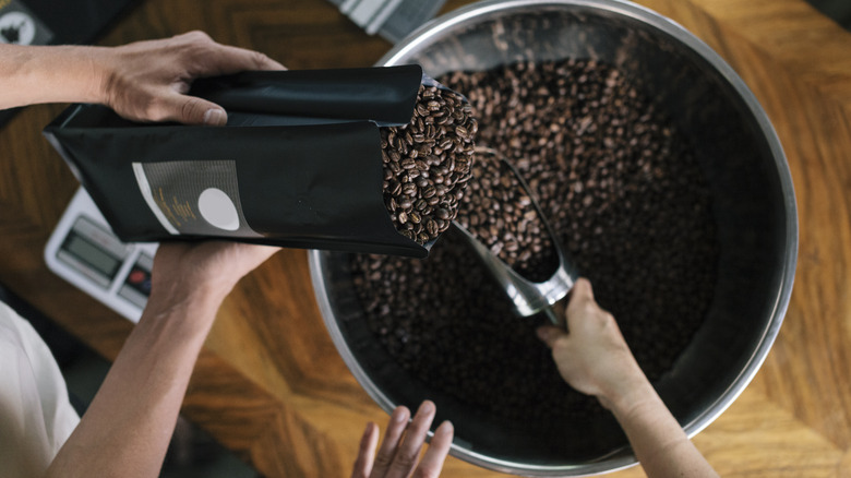 people filling roasted coffee bag