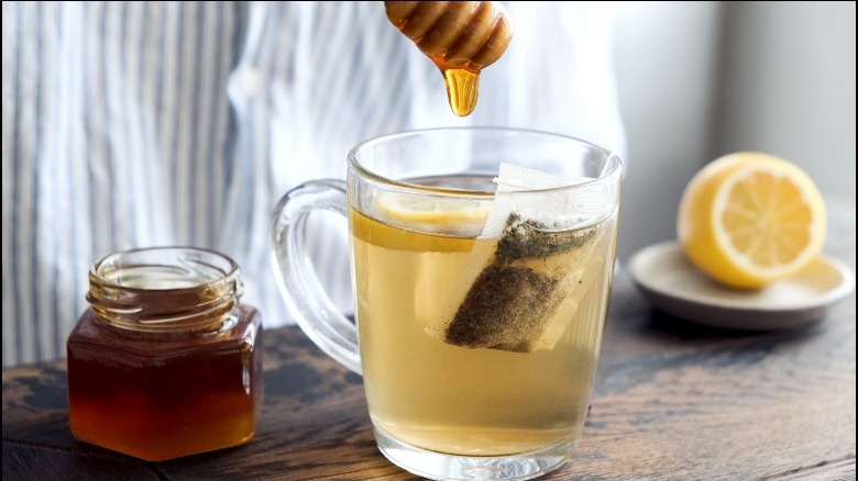 adding honey to iced tea