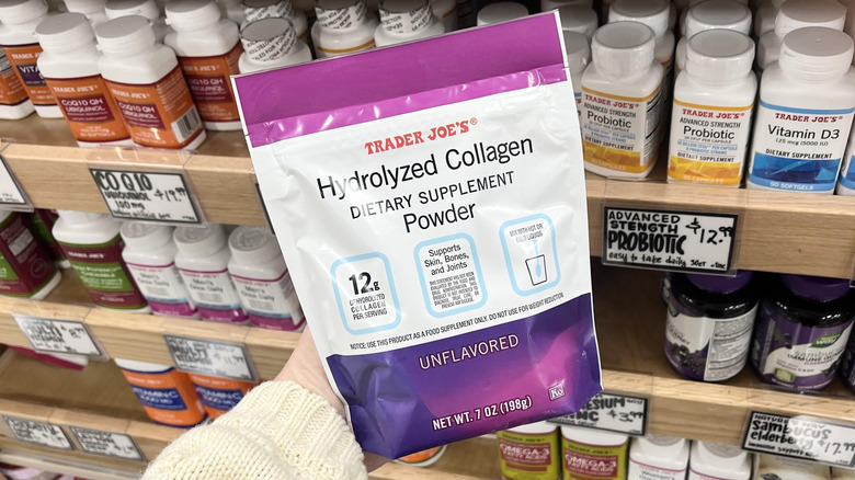 Hand holding bag of Trader Joe's collagen powder in store aisle