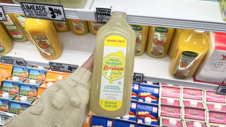 Hand holding Trader Joe's lemonade bottle in store aisle