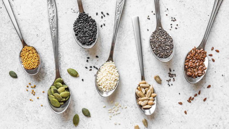 Flax, chia, pumpkin seeds on spoons