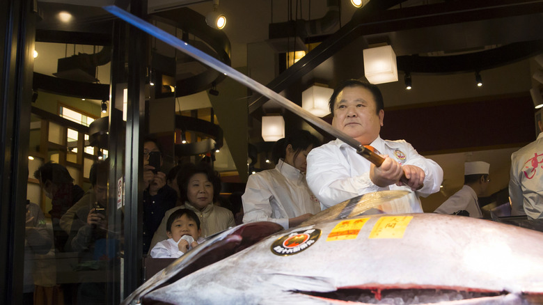 man wielding maguro bōchō in market