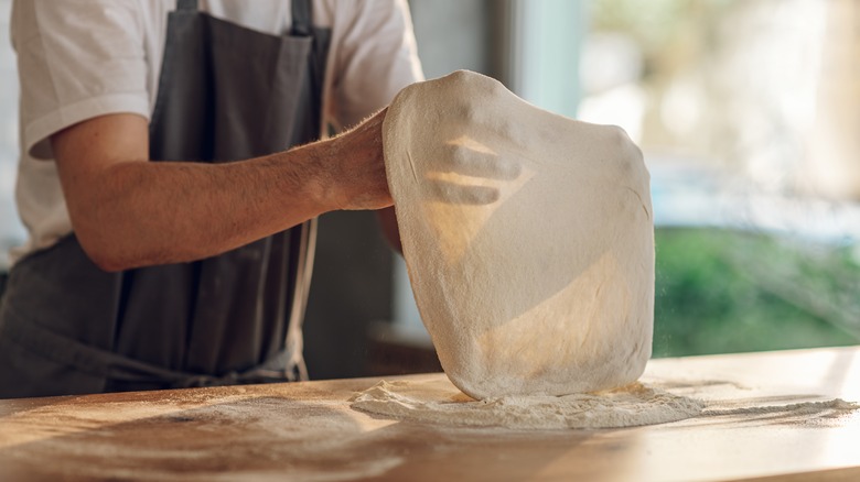 stretching thin crust pizza dough 