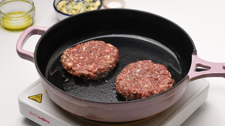 venison patties frying in pan