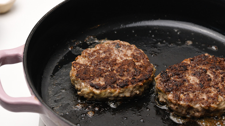 venison patties frying in pan