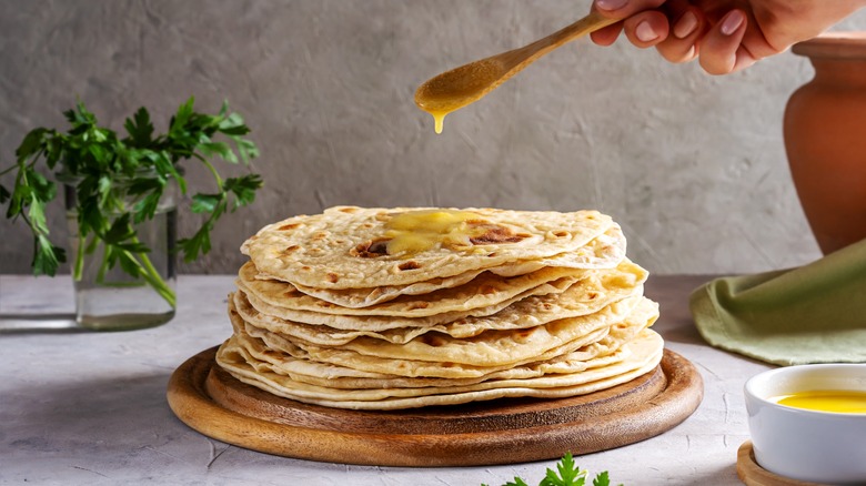 Drippinng ghee onto flatbread stack