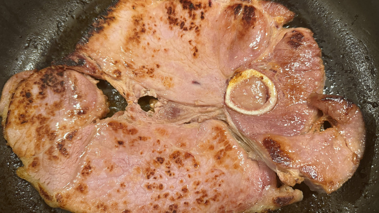 Ham steak cooking in pan