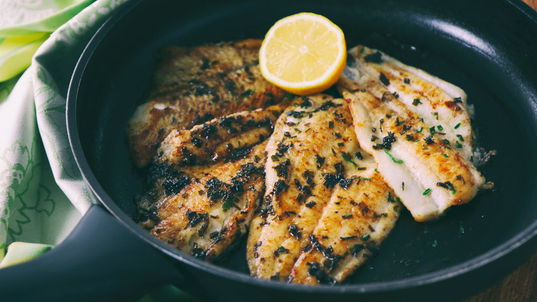 Flounder filets and lemon in skillet