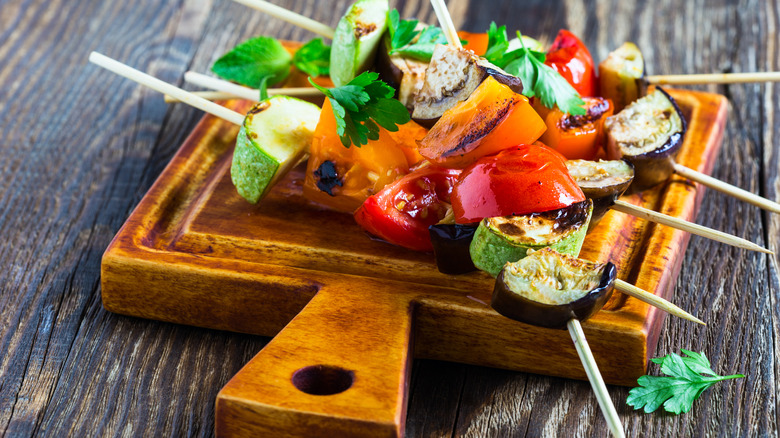 A few veggie kabobs on a wooden board