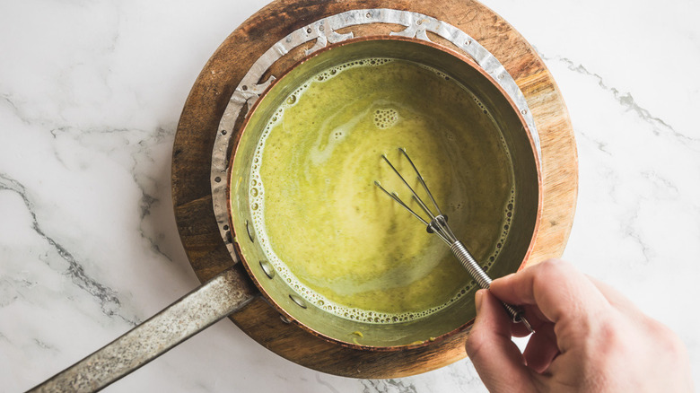 Hand whisks pistachio milk