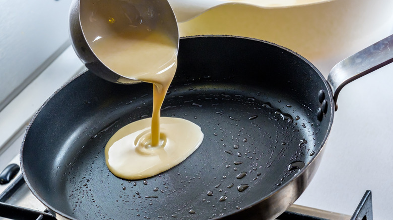 pouring pancake batter into skillet