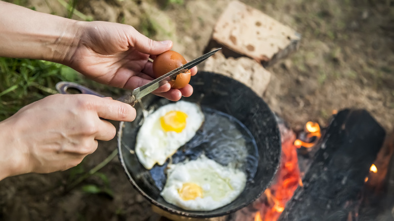 cracking egg over cast-iron skillet