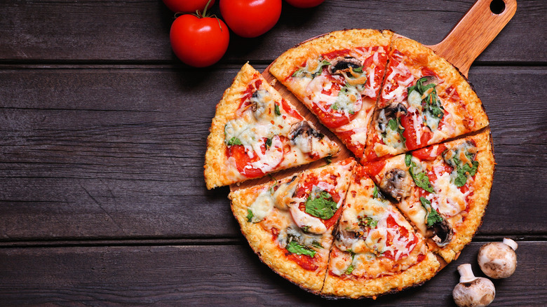 Cauliflower and mushroom pizza on a wooden slab