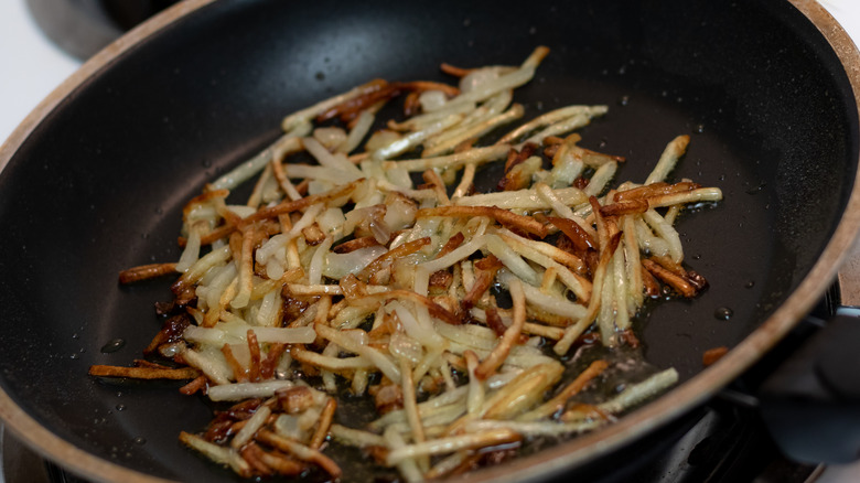 skillet hash browns frying in oil